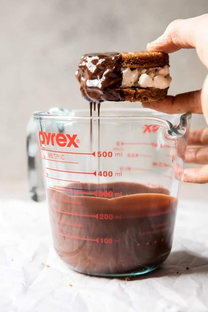 Chocolate Dipped Peanut Cookie Ice Cream Sandwiches | halfbakedharvest.com #icecream #chocolate #peanutbutter #summer dipping the Chocolate Dipped Peanut Cookie Ice Cream Sandwiches in chocolate