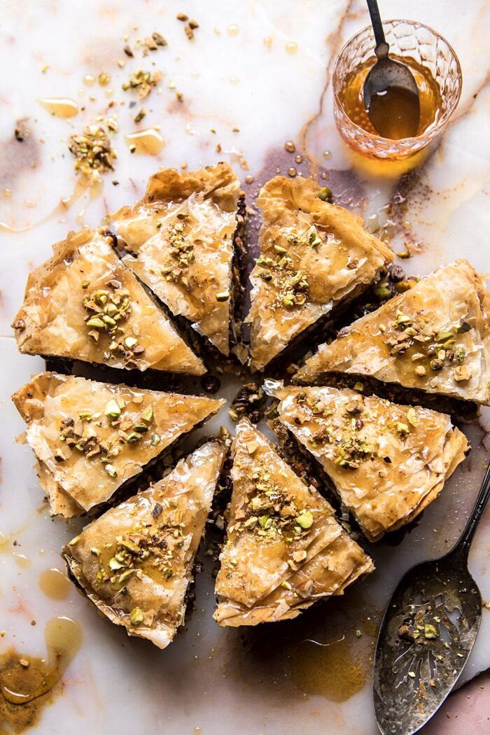 overhead photo of Easy Pistachio Chocolate Baklava with honey and spoon