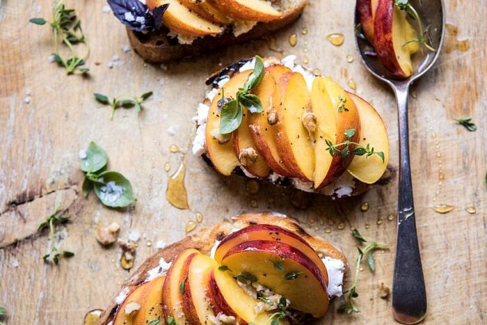 horizontal overhead photo of Thyme, Honey, Peach, and Goat Cheese Crostini 