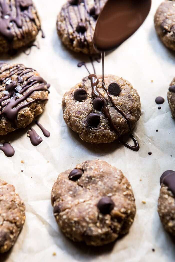 6 Ingredient No Bake Chocolate Chip Cookies | halfbakedharvest.com #cookies #healthy #chocolate #vegan #nobake side angle of drizzling chocolate over 6 Ingredient No Bake Chocolate Chip Cookies