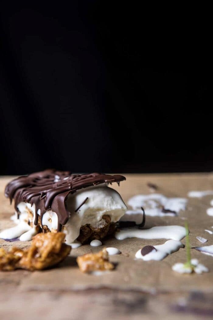 Chocolate Caramel Crunch Ice Cream Bars | halfbakedharvest.com #cereal #chocolate #icecream #dessert #summer side angle photo of Chocolate Caramel Crunch Ice Cream Bar broken in half