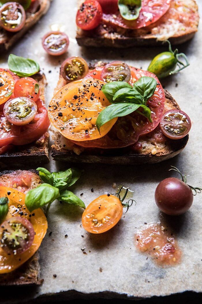 Heirloom Tomato, Basil, and Manchego Toast | halfbakedharvest.com #tomatoes #basil #easyrecipes #summerrecipes side angled photo of Heirloom Tomato, Basil, and Manchego Toast