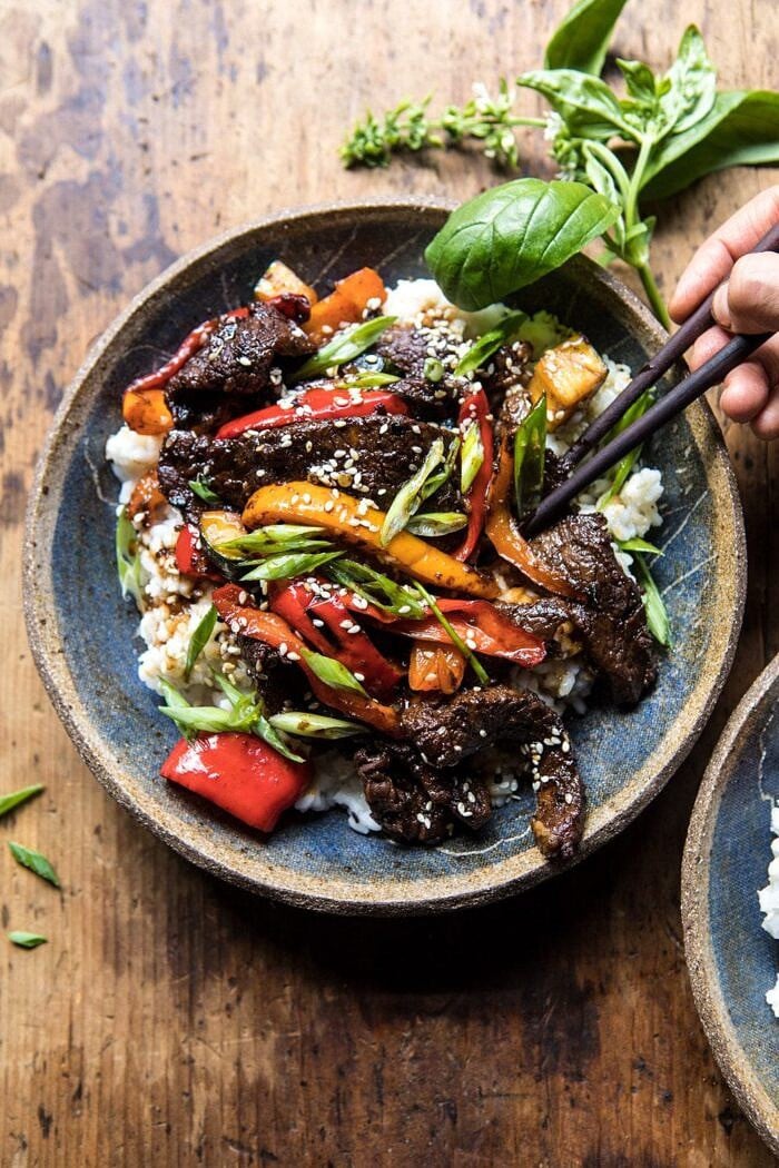 30 Minute Korean Beef and Peppers with Sesame Rice | halfbakedharvest.com #quick #easy #familydinner #korean #steak overhead photo of 30 Minute Korean Beef and Peppers with Sesame Rice with hands in photo