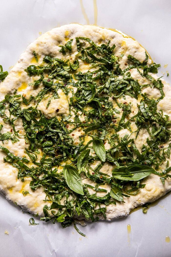 Pesto Zucchini and Peach Pizza with Burrata | halfbakedharvest.com #peach #pizza #summer #easyrecipes overhead photo of pizza dough with pesto