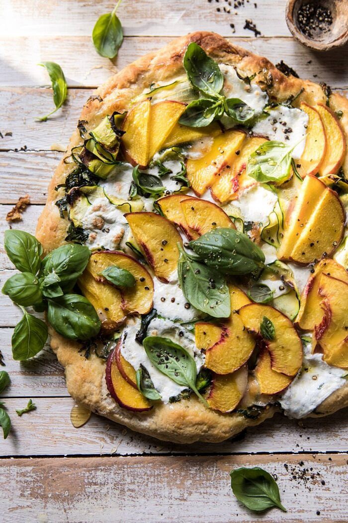 Pesto Zucchini and Peach Pizza with Burrata | halfbakedharvest.com #peach #pizza #summer #easyrecipes close up photo of Pesto Zucchini and Peach Pizza with Burrata
