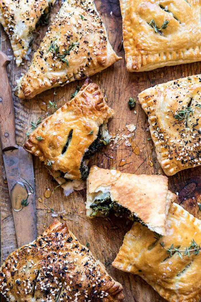 Caramelized Onion, Spinach, and Cheddar Flaky Pastries | halfbakedharvest.com #onions #tarts #fall #autumnrecipes #easy #holiday #appetizer overhead photo of broken Caramelized Onion, Spinach, and Cheddar Flaky Pastry
