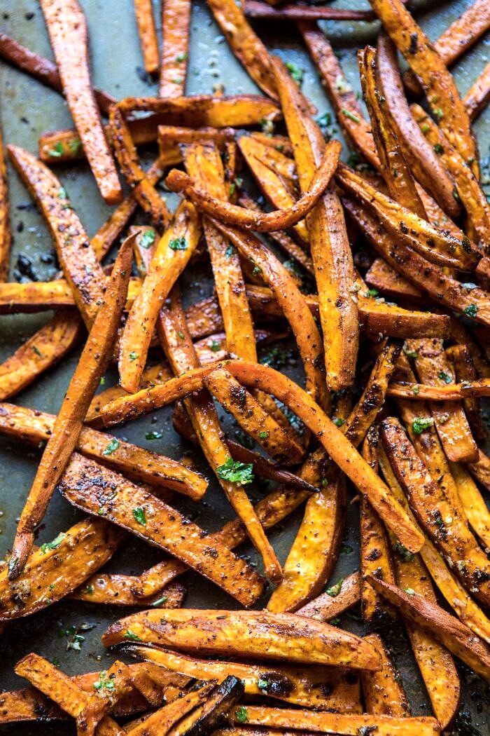 Herb Butter Baked Sweet Potato Fries | halfbakedharvest.com #quick #simple #easy #appetizers #sweetpotatoes #fallrecipes #autumn overhead photo of sweet potatoes fries on baking sheet after baking