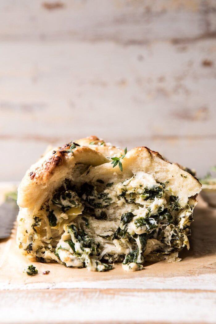 Herbed Spinach and Artichoke Pull Apart Pretzel Bread | halfbakedharvest.com #bread #appetizer #gamedayrecipes #easyrecipes front on, close up photo of Herbed Spinach and Artichoke Pull Apart Pretzel Bread