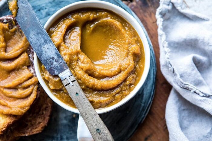 horizontal overhead photo of 6 Ingredient Spiced Pumpkin Butter with butter knife on bowl