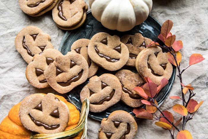 Milk Chocolate Stuffed Jack-O'-Lantern Cookies | halfbakedharvest.com #halloween #thanksgiving #cookies #easyrecipes #chocolate #holidayrecipes #fallrecipes horizontal photo of Milk Chocolate Stuffed Jack-O'-Lantern Cookies
