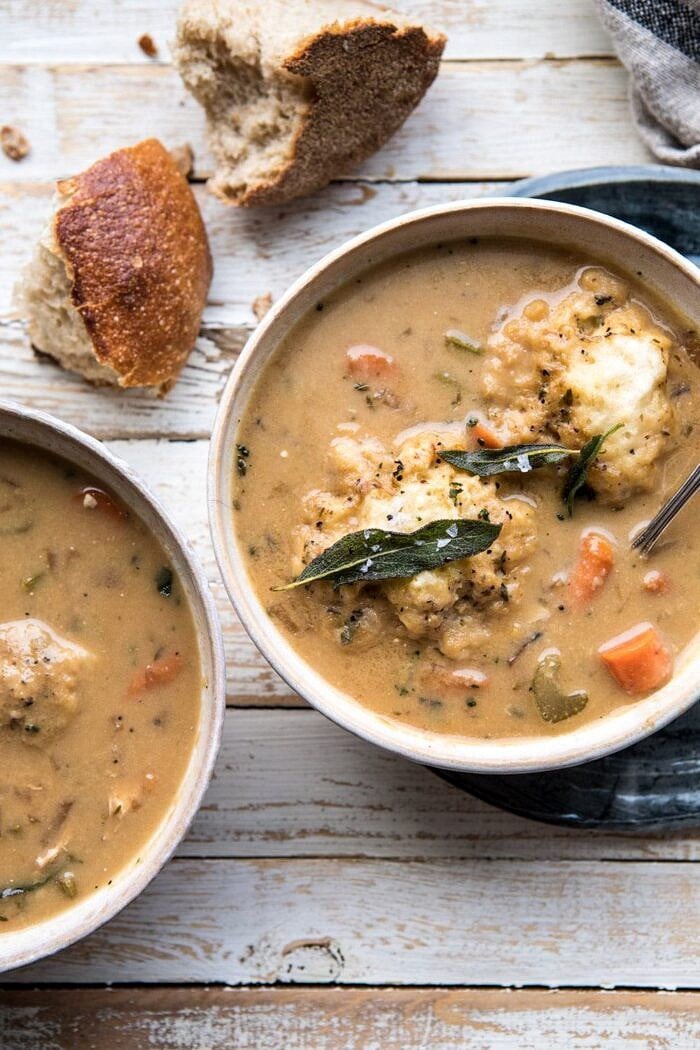 One Pot Chicken and Sage Dumplings | halfbakedharvest.com #comfortfood #chicken #soup #fallrecipes #easyrecipes overhead close up photo of One Pot Chicken and Sage Dumplings with bread on table and spoon in bowl