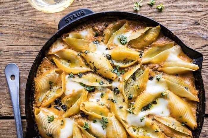 horizontal photo of Spicy Pumpkin and Pesto Cheese Stuffed Shells in skillet