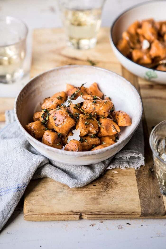 Sweet Potato Gnocchi with Herbed White Wine Pan Sauce | #fallrecipes #simple #cozyrecipes #sweetpotato #gnocchi Sweet Potato Gnocchi with Herbed White Wine Pan Sauce in bowls with wine glasses and towel in photo