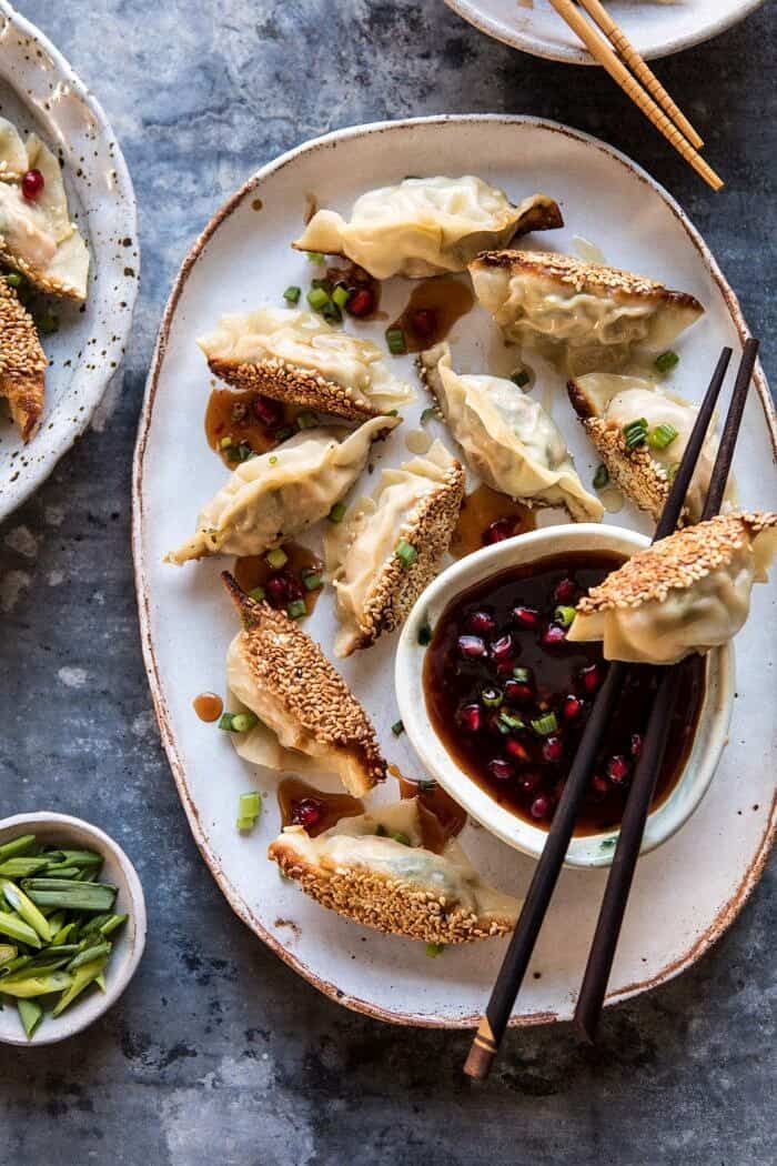 Ginger Sesame Chicken Potstickers with Sweet Chili Pomegranate Sauce | halfbakedharvest.com #asianrecipes #potstickers #dumplings #healthy overhead photo of Ginger Sesame Chicken Potstickers with Sweet Chili Pomegranate Sauce