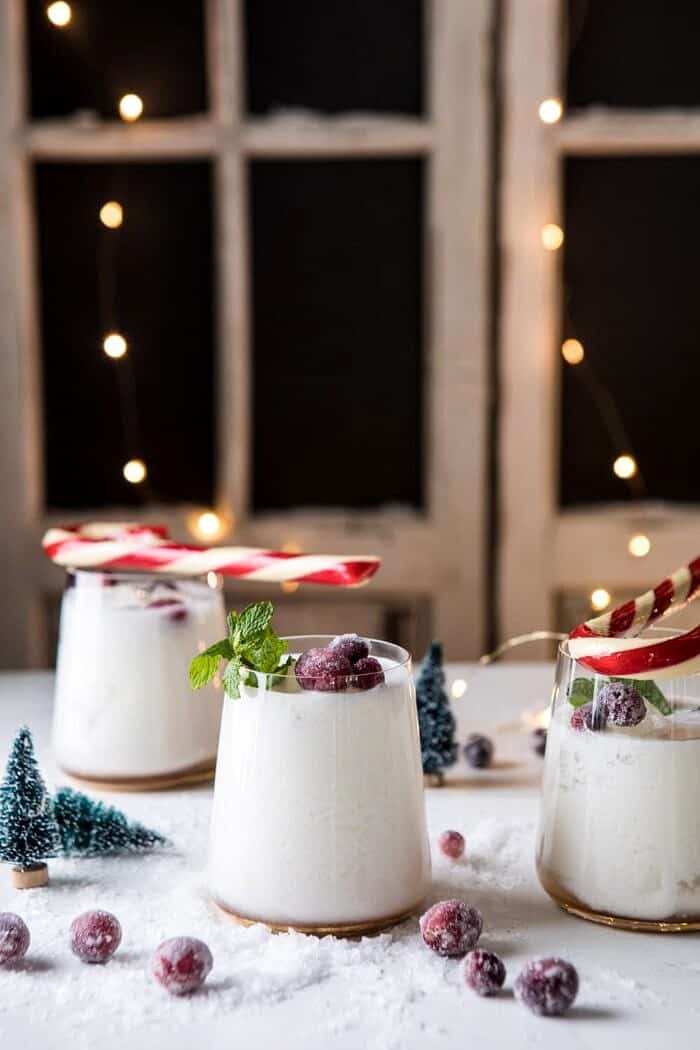 Christmas Snowstorm Margarita | halfbakedharvest.com #margarita #coconut #christmas #cocktailsaturday #christmascocktails side angle photo of Christmas Snowstorm Margarita with lights in background