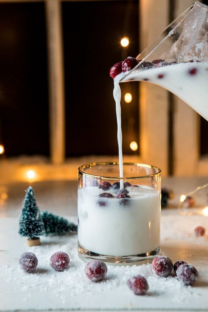 Christmas Snowstorm Margarita | halfbakedharvest.com #margarita #coconut #christmas #cocktailsaturday #christmascocktails Christmas Snowstorm Margarita being poured into glass from pitcher