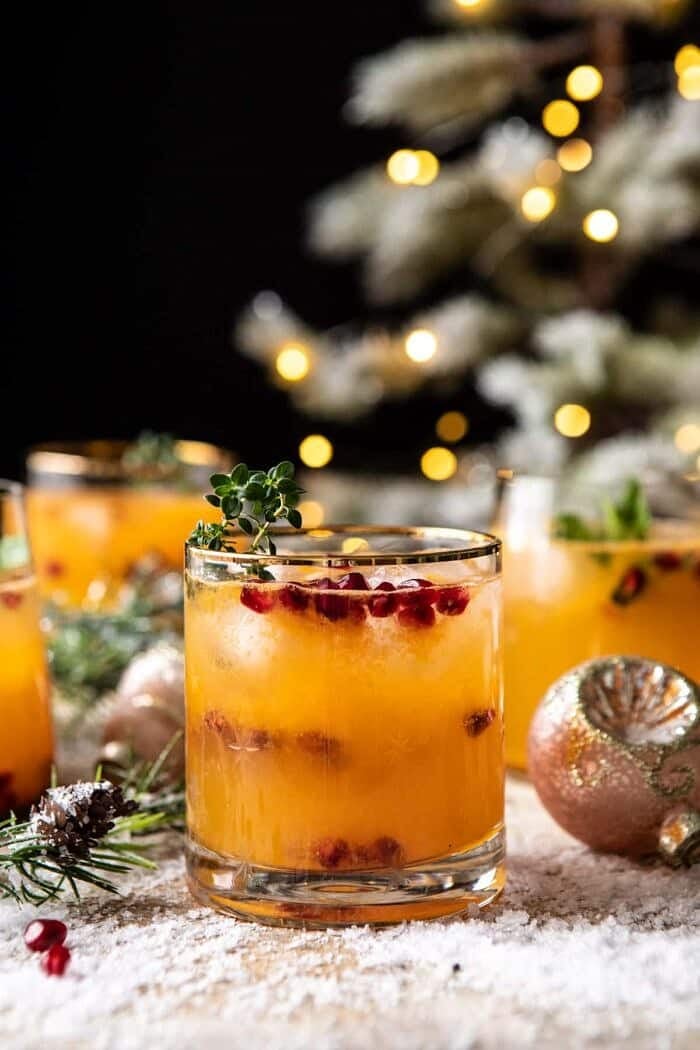 side angle close up photo of Holy Jolly Christmas Citrus Cocktail with tree in background
