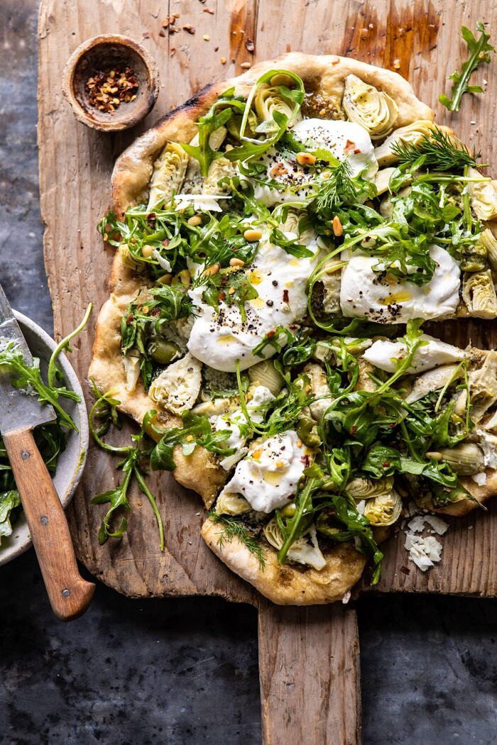 Artichoke Pesto and Burrata Pizza with Lemony Arugula | halfbakedharvest.com #pizza #healthy #burrata #easyrecipes overhead photo of Artichoke Pesto and Burrata Pizza with Lemony Arugula after being cut