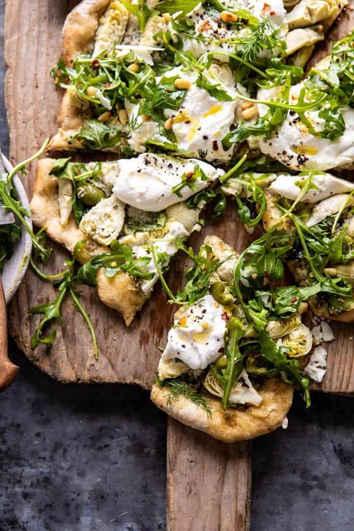 Artichoke Pesto and Burrata Pizza with Lemony Arugula | halfbakedharvest.com #pizza #healthy #burrata #easyrecipes close up photo of Artichoke Pesto and Burrata Pizza with Lemony Arugula