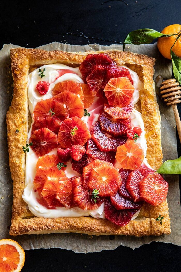 The Simplest Ombrè Citrus Cream Tart | halfbakedharvest.com #dessert #winter #citrus #healthyrecipes #easyrecipes overhead photo of The Simplest Ombrè Citrus Cream Tart with honey drizzler in photo