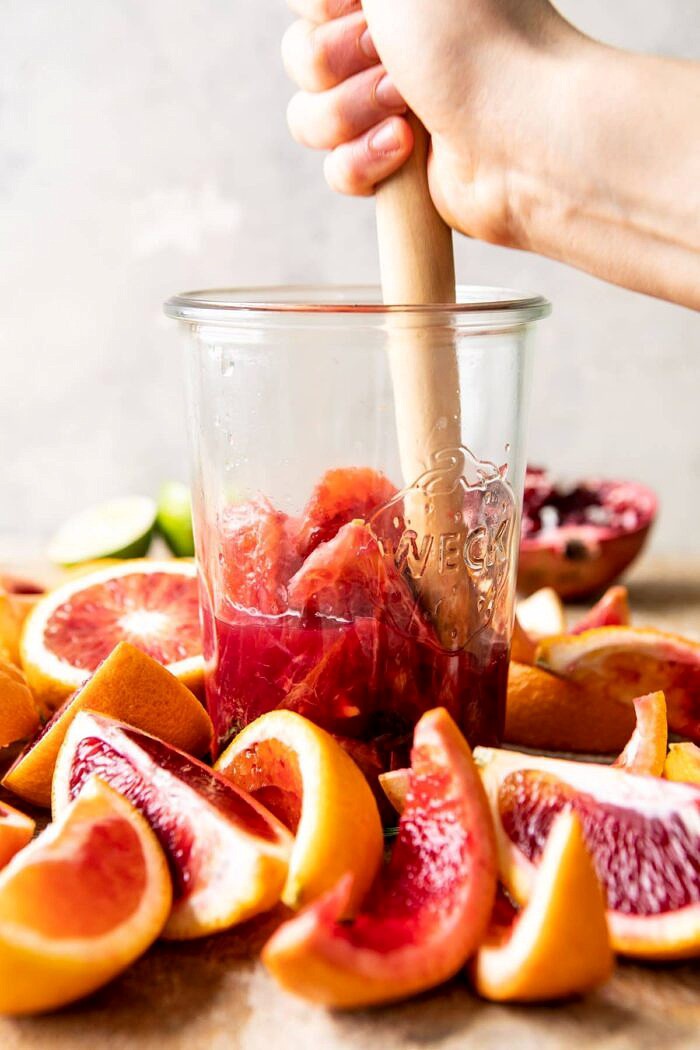 Winter Citrus Tequila Smash being muddled together