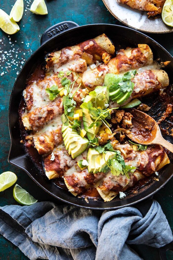 overhead photo of Chipotle Cheddar Cauliflower Black Bean Enchiladas with spoon in dish
