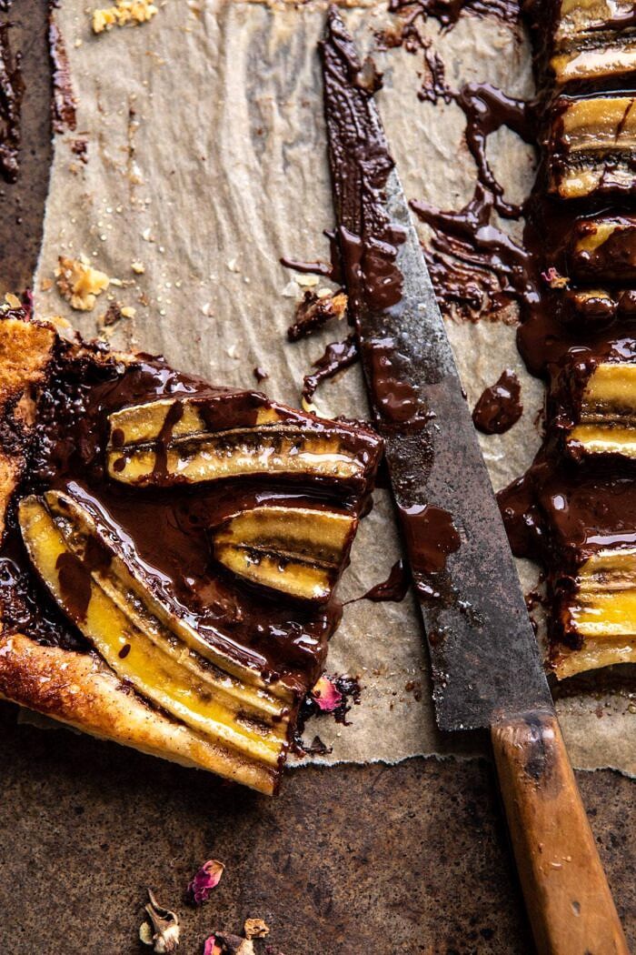Warm Chocolate Banana Galette | halfbakedharvest.com #banana #chocolate #dessert #easyrecipes #chocolaterecipes #baking overhead photo of Warm Chocolate Banana Galette square with knife in photo and melted chocolate on knife