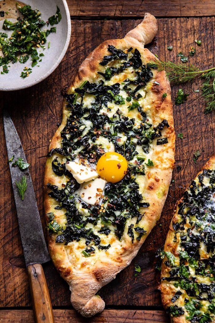 Khachapuri (Georgian Cheese Bread) with Kale and Herb Sauce | halfbakedharvest.com #pizza #easyrecipes #cheese #bread overhead photo of Khachapuri (Georgian Cheese Bread) with Kale and Herb Sauce