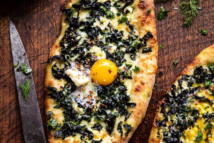 Khachapuri (Georgian Cheese Bread) with Kale and Herb Sauce | halfbakedharvest.com #pizza #easyrecipes #cheese #bread horizontal photo of Khachapuri (Georgian Cheese Bread) with Kale and Herb Sauce