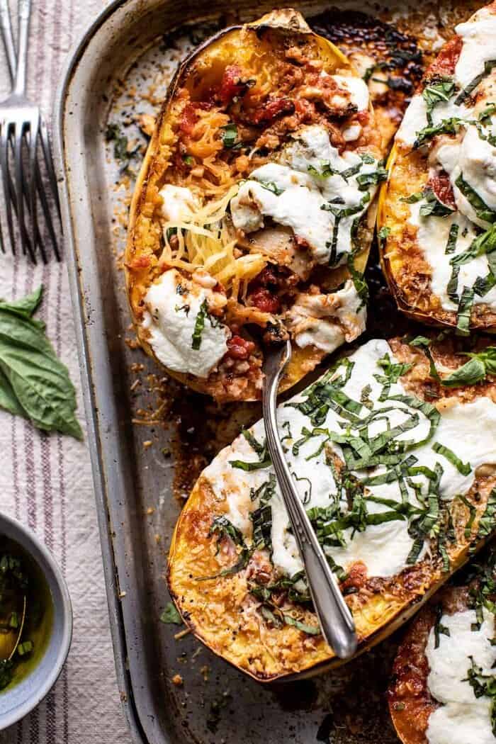 Spicy Tomato Parmesan Stuffed Spaghetti Squash | halfbakedharvest.com #spaghettisquash #healthyrecipes #easyrecipes #dinner overhead close up photo of Spicy Tomato Parmesan Stuffed Spaghetti Squash with fork in squash