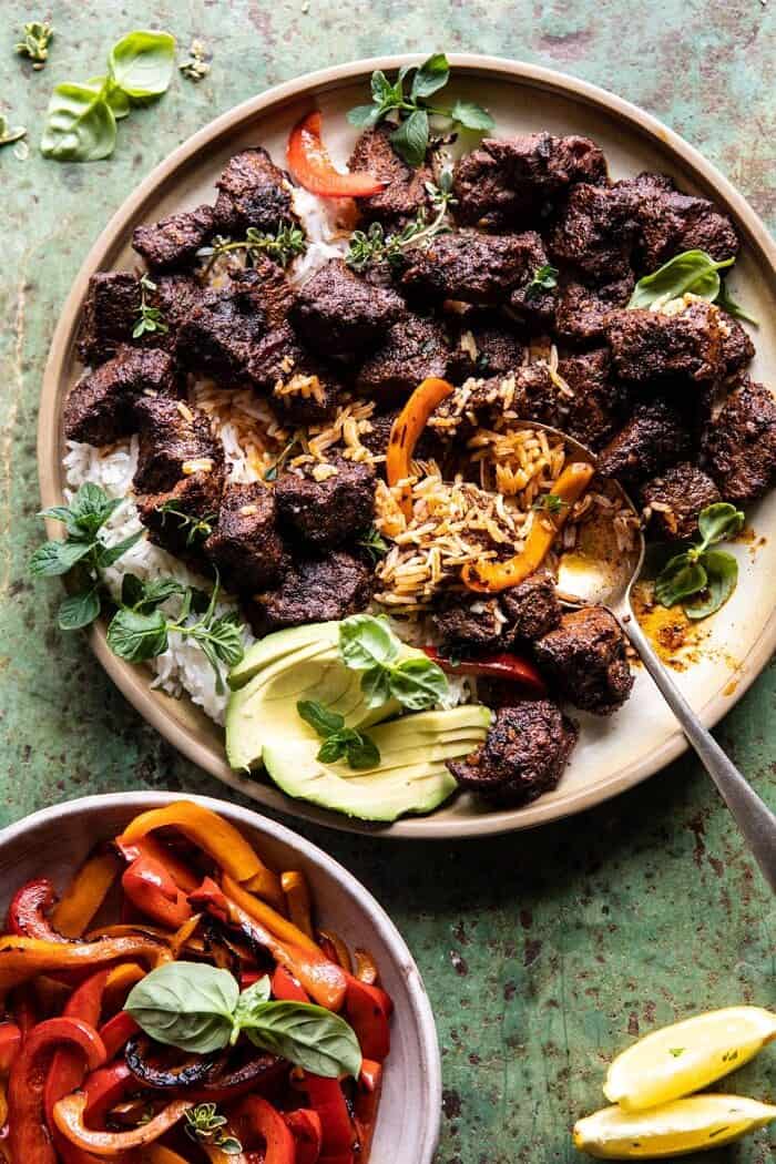 overhead photo of 30 Minute Cajun Butter Steak and Peppers with spoon in dish pulling up rice