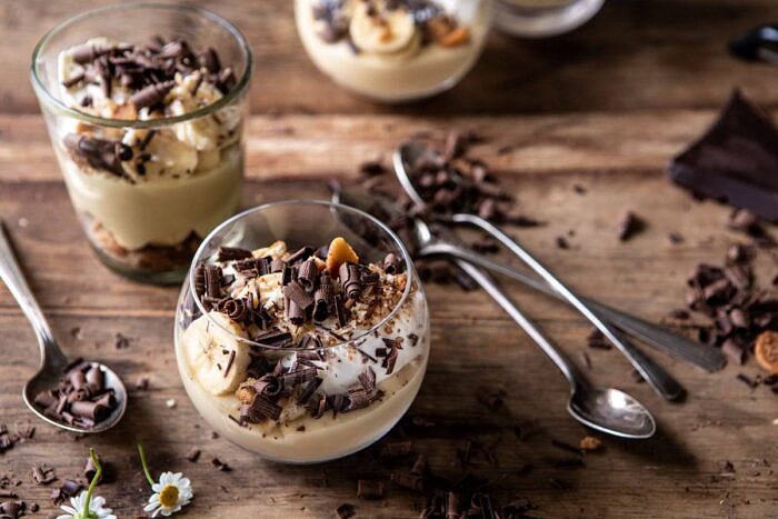 Coconut Banana Cream Pie Parfaits | halfbakedharvest.com #coconutpie #banana #dessertrecipes #easter horizontal photo of Coconut Banana Cream Pie Parfaits with 2 parfaits in photo