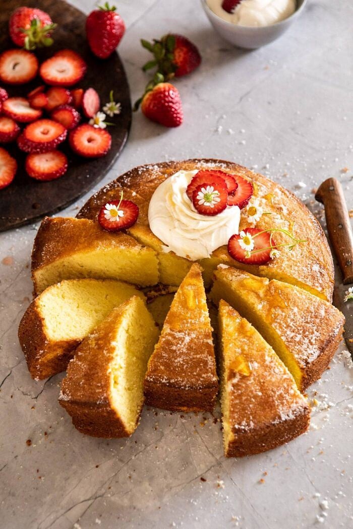 Strawberry Chamomile Olive Oil Cake with Honeyed Ricotta | halfbakedharvest.com #cake #dessert #springrecipes #Easter #strawberry side angled photo of Strawberry Chamomile Olive Oil Cake with Honeyed Ricotta with 6 slices cut out