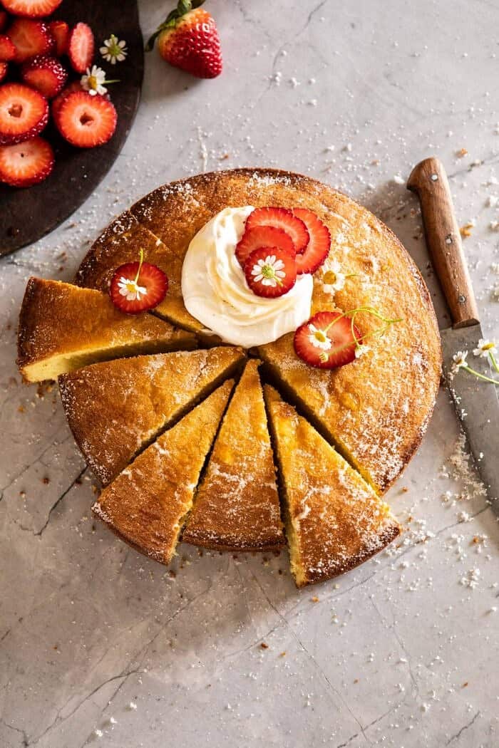 Strawberry Chamomile Olive Oil Cake with Honeyed Ricotta | halfbakedharvest.com #cake #dessert #springrecipes #Easter #strawberry overhead photo of Strawberry Chamomile Olive Oil Cake with Honeyed Ricotta and 6 slices cut from cake