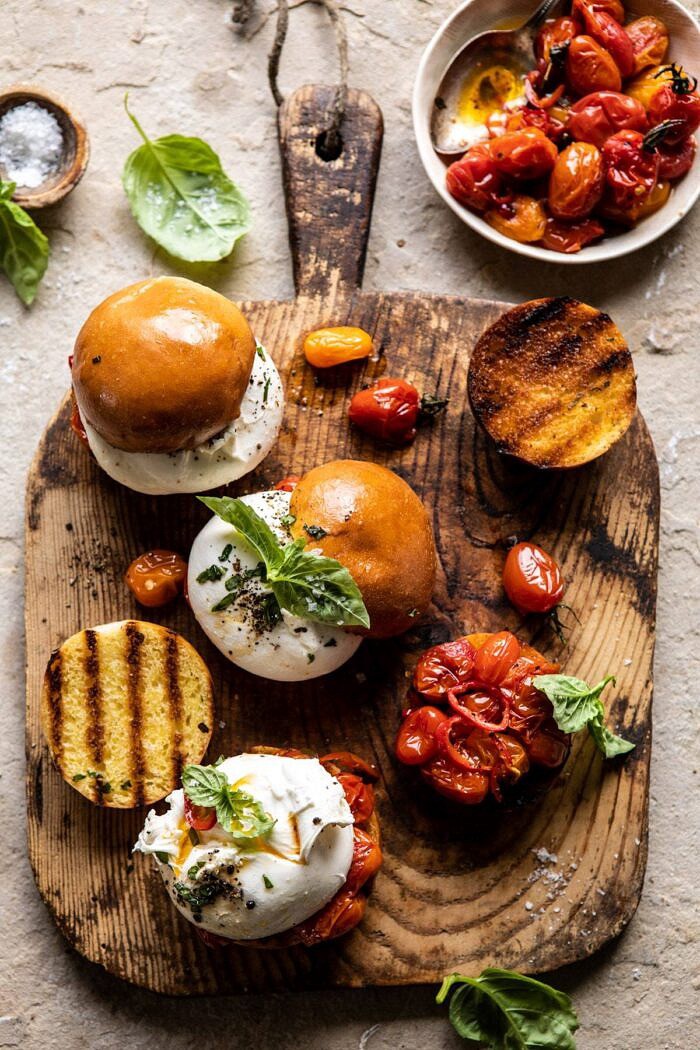 Roasted Caprese Burrata Sliders | halfbakedharvest.com #summerrecipes #appetizer #mothersday #burrata overhead photo of Roasted Caprese Burrata Sliders on cutting board