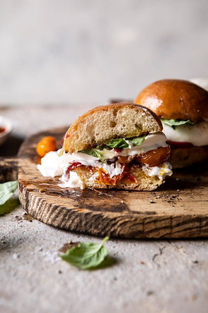 Roasted Caprese Burrata Sliders | halfbakedharvest.com #summerrecipes #appetizer #mothersday #burrata side angled photo of Roasted Caprese Burrata Sliders cut in half