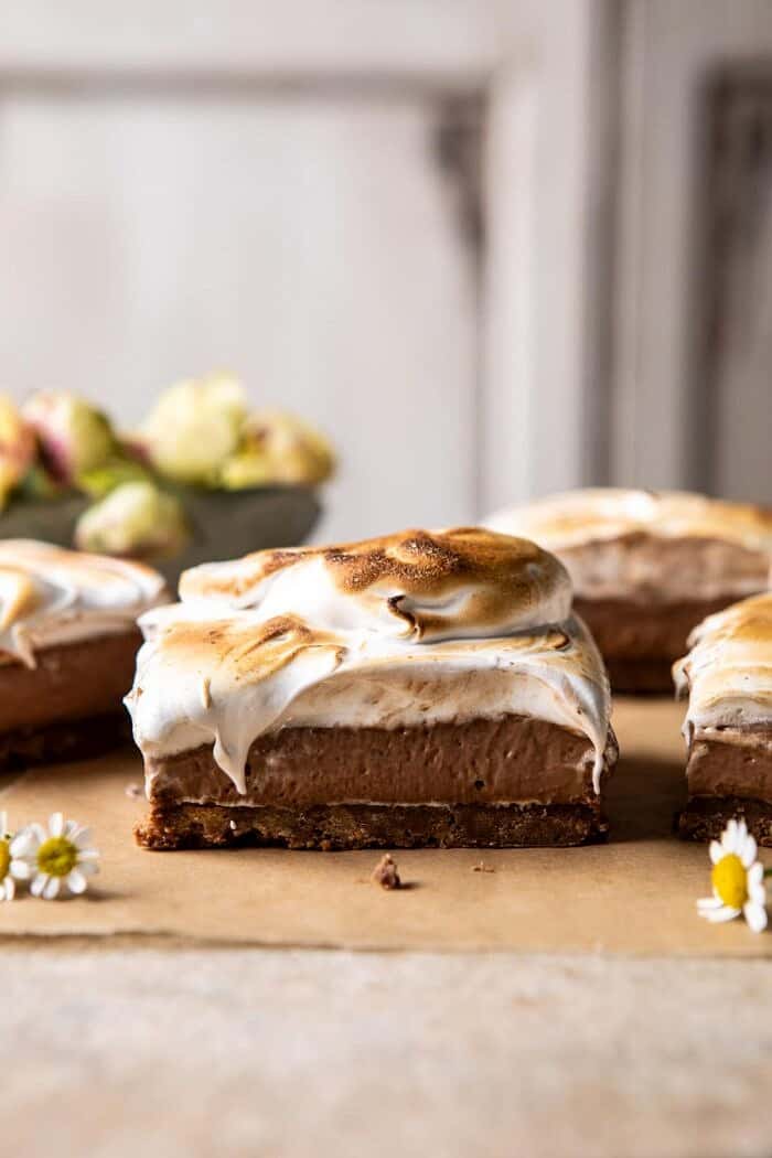 S'mores Chocolate Mousse Bars | halfbakedharvest.com #smores #dessert #chocolate #summerrecipes front on close up photo of S'mores Chocolate Mousse Bars with flowers in the background