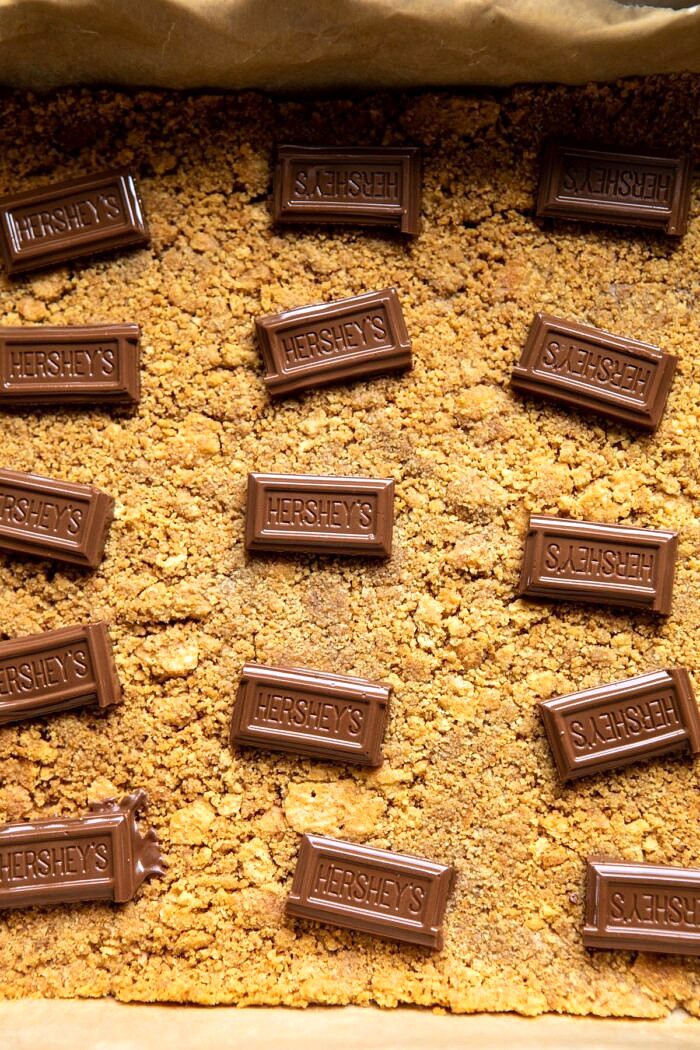 S'mores Chocolate Mousse Bars | halfbakedharvest.com #smores #dessert #chocolate #summerrecipes milk chocolate sitting on graham crackers before adding mousse