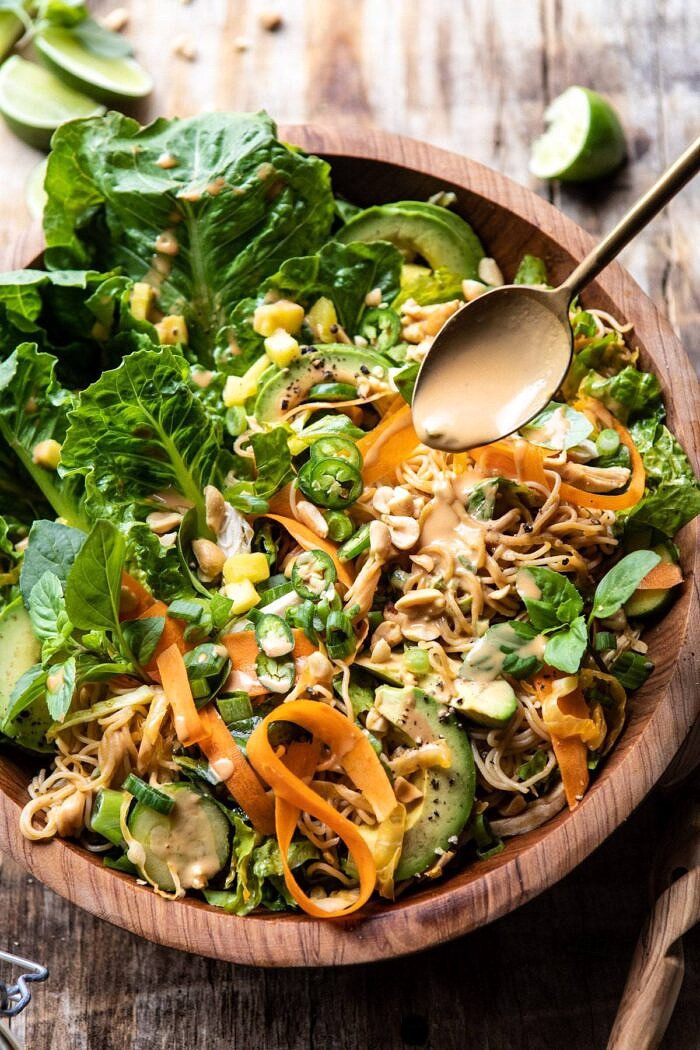 Thai Peanut Chicken Ramen Noodle Salad | halfbakedharvest.com #healthyrecipes #thai #peanutbuter #salad Thai Peanut Chicken Ramen Noodle Salad with spoon drizzling on peanut sauce