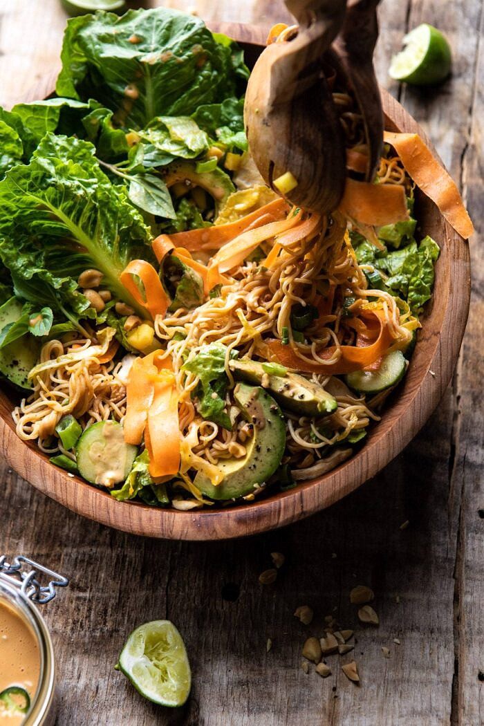 Thai Peanut Chicken Ramen Noodle Salad | halfbakedharvest.com #healthyrecipes #thai #peanutbuter #salad Thai Peanut Chicken Ramen Noodle Salad with tongs pulling up noodles out of bowl