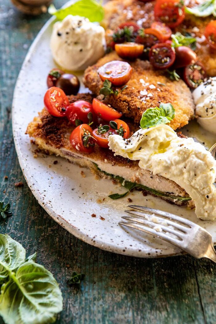 Basil Chicken Saltimbocca with Marinated Tomatoes and Burrata | halfbakedharvest.com #chicken #tomatoes #basil #summerrecipes side angle photo of Basil Chicken Saltimbocca with Marinated Tomatoes and Burrata with chicken piece cut in half
