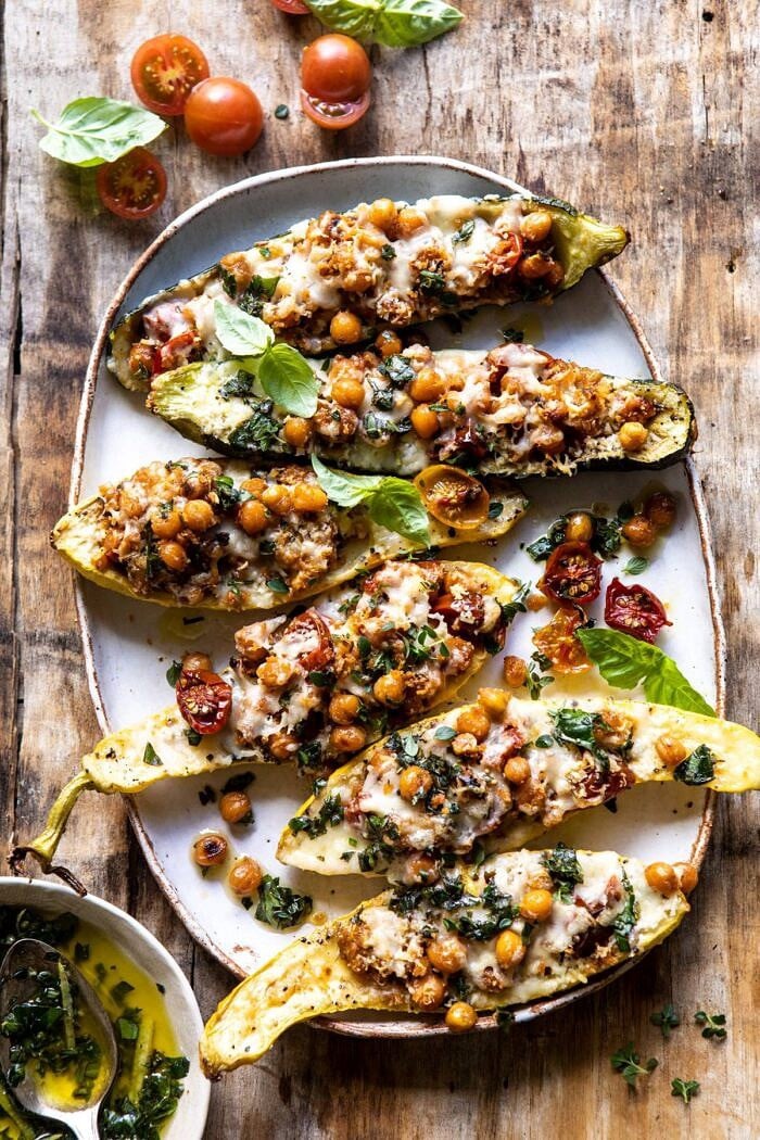 Spicy Chickpea and Cheese Stuffed Zucchini | halfbakedharvest.com #healthy #easyrecipes #summerrecipes #zucchini overhead photo of Spicy Chickpea and Cheese Stuffed Zucchini on platter