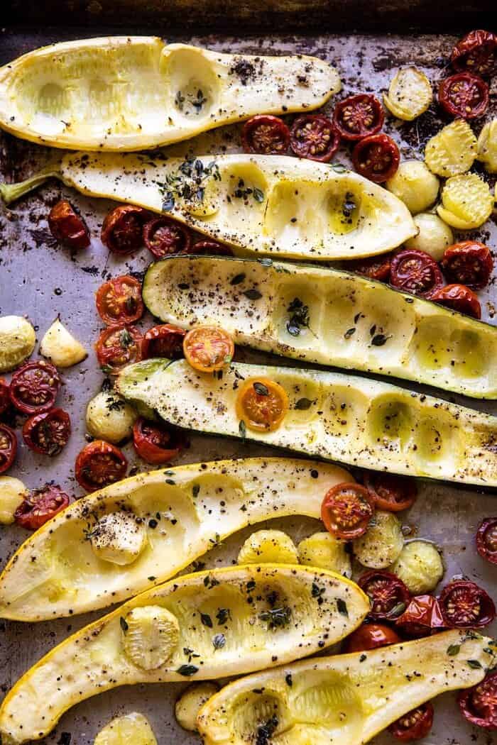 Spicy Chickpea and Cheese Stuffed Zucchini | halfbakedharvest.com #healthy #easyrecipes #summerrecipes #zucchini zucchini and tomatoes after roasting on baking sheet