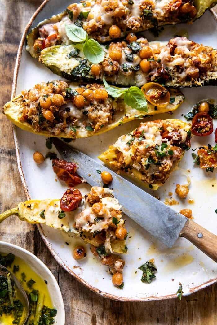 Spicy Chickpea and Cheese Stuffed Zucchini | halfbakedharvest.com #healthy #easyrecipes #summerrecipes #zucchini overhead photo of Spicy Chickpea and Cheese Stuffed Zucchini with zucchini cut in half and filling spilling out