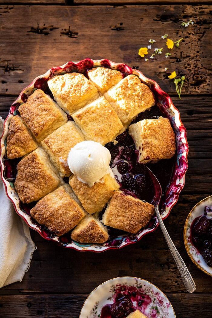 Blackberry Lavender Cobbler | halfbakedharvest.com #cobbler #blackerry #dessert overhead photo of Blackberry Lavender Cobbler with ice cream on cobbler and spoon in baking dish