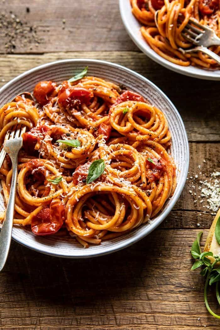 Bucatini Amatriciana | halfbakedharvest.com #pasta #easyrecipes #italian side angled photo of Bucatini Amatricianawith fork in bowl