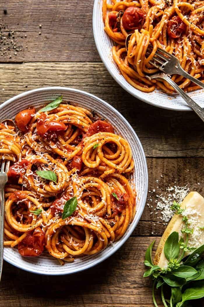 Bucatini Amatriciana | halfbakedharvest.com #pasta #easyrecipes #italian overhead 3/4 angled photo of Bucatini Amatriciana with parmesan and basil in photo