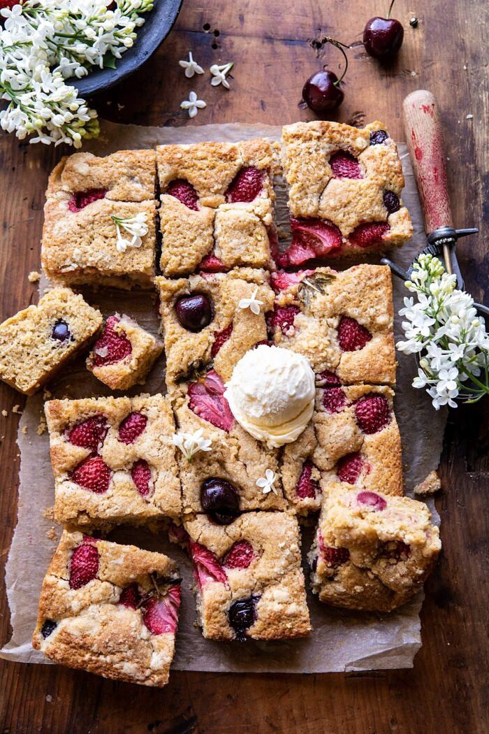 Cherry Strawberry Streusel Cake | halfbakedharvest.com #easyrecipes #cake #sheetcake #summerdessert overhead photo of Cherry Strawberry Streusel Cake with cake pieces cut and ice cream on cake