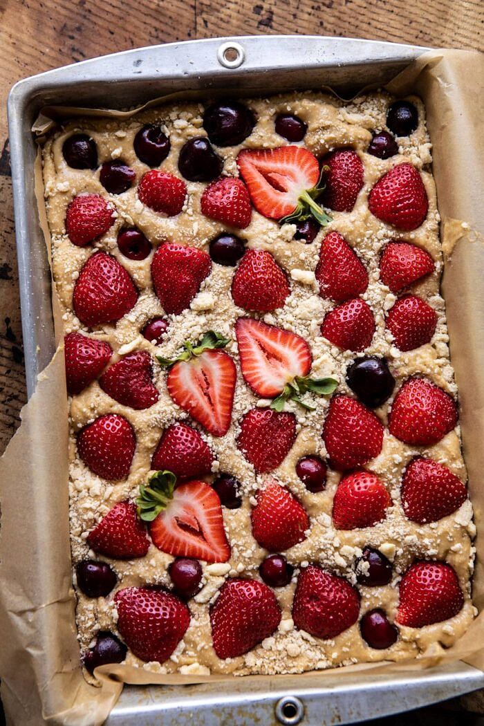 Cherry Strawberry Streusel Cake | halfbakedharvest.com #easyrecipes #cake #sheetcake #summerdessert overhead photo of Cherry Strawberry Streusel Cake in baking pan before baking