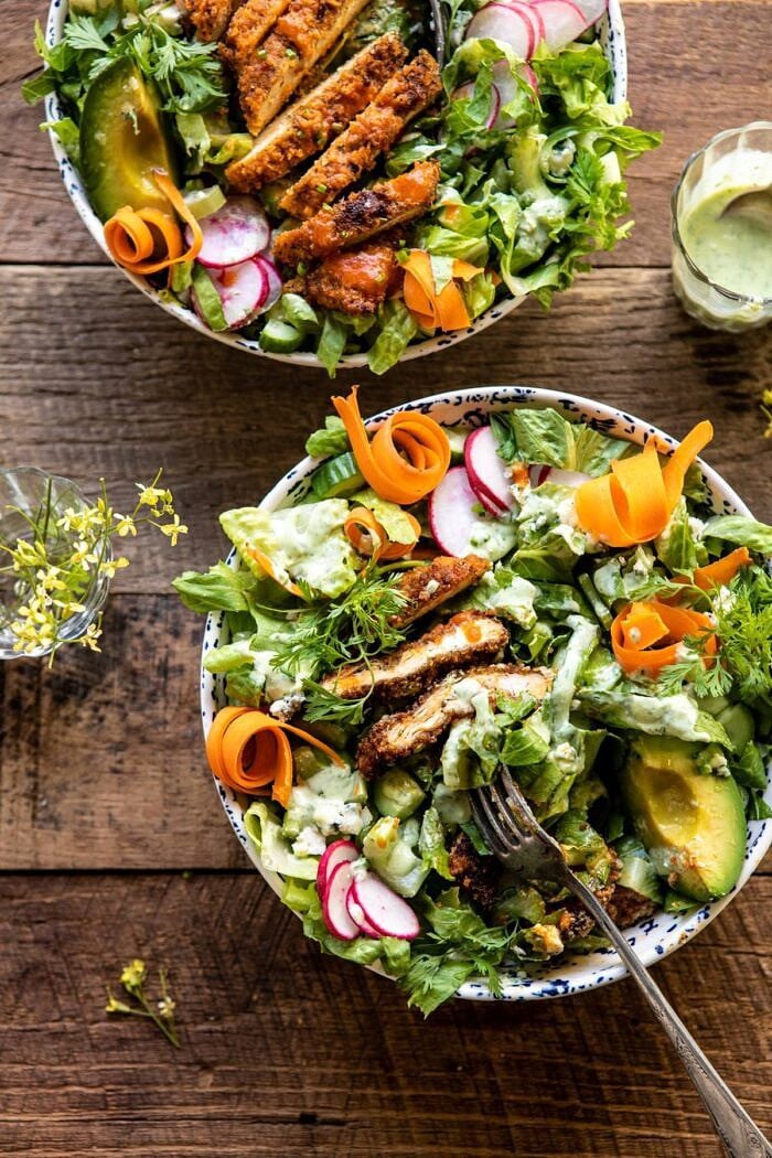 Crispy Buffalo Ranch Chicken Salad with Goddess Dressing | halfbakedharvest.com #buffalochicken #salad #healthy #dinner overhead photo of Crispy Buffalo Ranch Chicken Salad with Goddess Dressing and fork in salad to showing the inside of the chicken